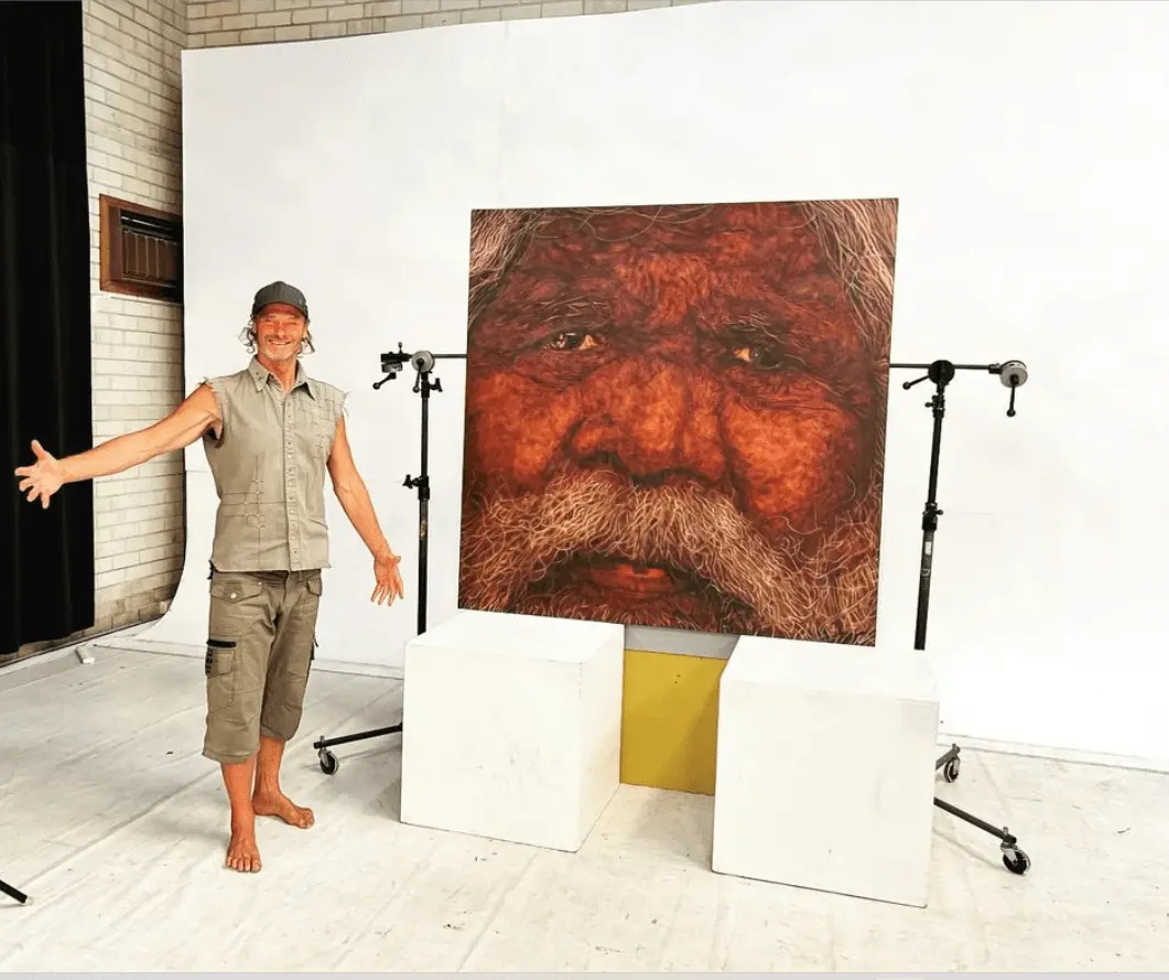 A image of Michael standing beside his famous artwork Gulpilil
